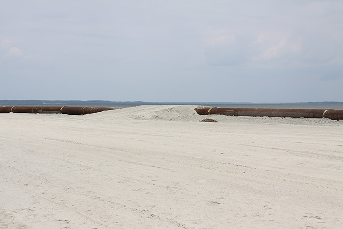 Temporary sand beach access ramp constructed over pipe