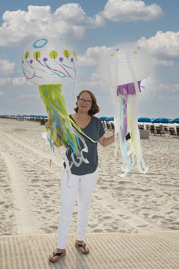 Natalie Harvey on the Beach holding parade lanterns