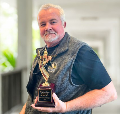 Mike Visokay posing holding the Employee of the Year trophy